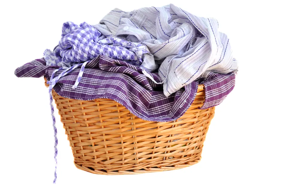 A wicker laundry basket full of checked shirts